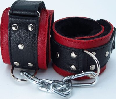 Красно-чёрные кожаные наручники с меховым подкладом Наручники выполнены из красной натуральной кожи, легко, но надежно фиксируются черными ремнями на липучке, позволяя выбрать нужный размер, подойдут на обхват руки от 15 до 26 см. Аксессуар декорирован заклепками. Кожаное соединение на карабинах фиксирует наручники вместе. Мягкий подклад из меха обеспечит комфортное пребывание в образе, помогая полностью погрузиться в БДСМ игру. Ширина - 5,5 см. Длина соединения - 14 см. Страна: Россия. Материал: натуральная кожа.