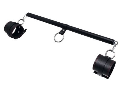 Черная распорка для ног с кожаными манжетами Набор для бандажа состоит из большой распорки с тремя точками крепления и пары оков с контрастной строчкой красного цвета, всё это в фирменной деревянной коробке Pecado BDSM. С этим набором расширить возможности и способы фиксации проще простого! Варианты и комбинации ограничения свободы партнера зависят от вашей фантазии и желаний. Распорка позволяет зафиксировать ноги партнера в широко разведенной позиции. Частичное обездвиживание и невозможность двигать руками или ногами дают вам полную власть над партнером – взрослые игры для взрослых. Кольцо посередине распорки позволяет использовать дополнительные аксессуары, либо приковать партнера к кровати или другому предмету и экспериментировать с позициями и ощущениями. Длина распорки - 50 см. Длина оков - 25 см., ширина - 6,5 см. Страна: Россия. Материал: металл, натуральная кожа.