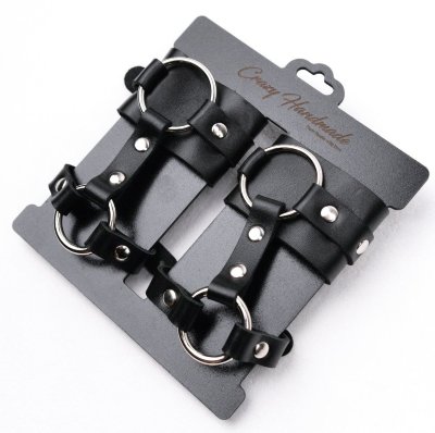 Черные наручники с креплением на кисть руки Наручники с креплением на кисть руки выполнены из натуральной кожи. Декорированы заклепками и металлическими кольцами. Страна: Россия. Материал: натуральная кожа.
