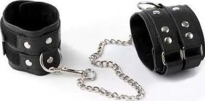 Чёрные кожаные оковы Изготавливаются из натуральной кожи с велюровой подкладой. При изготовлении использована фурнитура с никелевым покрытием. Между слоем основы и подкладой проложена мягкая прокладка. Соединяются между собой цепочкой с двумя карабинами на концах. Не нарушают кровообращение, надёжно фиксируются на щиколотках с помощью двух ремешков. Размер универсальный. Длина цепи - 35 см. Страна: Россия. Материал: натуральная кожа.