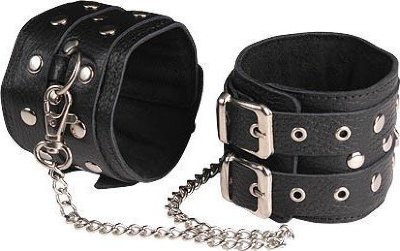 Чёрные кожаные оковы, соединенные цепочкой Изготавливаются из натуральной кожи с велюровой подкладой. При изготовлении использована фурнитура с никелевым покрытием. Между слоем основы и подкладой проложена мягкая прокладка. Соединяются между собой цепочкой с двумя карабинами на концах. Не нарушают кровообращение, надёжно фиксируются на щиколотках с помощью двух ремешков. Размер универсальный. Длина цепочки - 35 см. Страна: Россия. Материал: натуральная кожа.