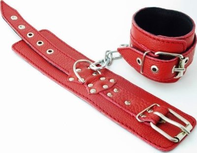 Красные кожаные наручники Наручники выполнены из натуральной кожи красного цвета. Декорированы заклепками и бантом с металлическим кольцом. Наручники надежно фиксируются пряжками и ремнями, позволяющими выбрать нужный размер, подойдут на обхват руки от 16 до 25 см. Нежный подклад из черной кожи обеспечивает комфорт, кожаное соединение на карабинах фиксирует наручники вместе. Аксессуар позволяет в полной мере насладиться сексом в стиле БДСМ. Ширина - 6 см. Длина соединения - 14 см. Страна: Россия. Материал: натуральная кожа.