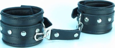 Наручники из гладкой кожи Наручники выполнены из гладкой черной натуральной кожи. Изделие декорировано металлическими заклёпками. Наручники надежно фиксируются пряжками и ремнями, позволяющими выбрать нужный размер, подойдут на обхват руки от 15 до 25 см. Кожаное соединение на карабинах фиксирует наручники вместе. На каждом аксессуаре полукольцо из сварной фурнитуры. Стильные наручники помогут воплотить эротические фантазии в реальность. Ширина - 6 см. Длина соединения - 14 см. Страна: Россия. Материал: натуральная кожа.